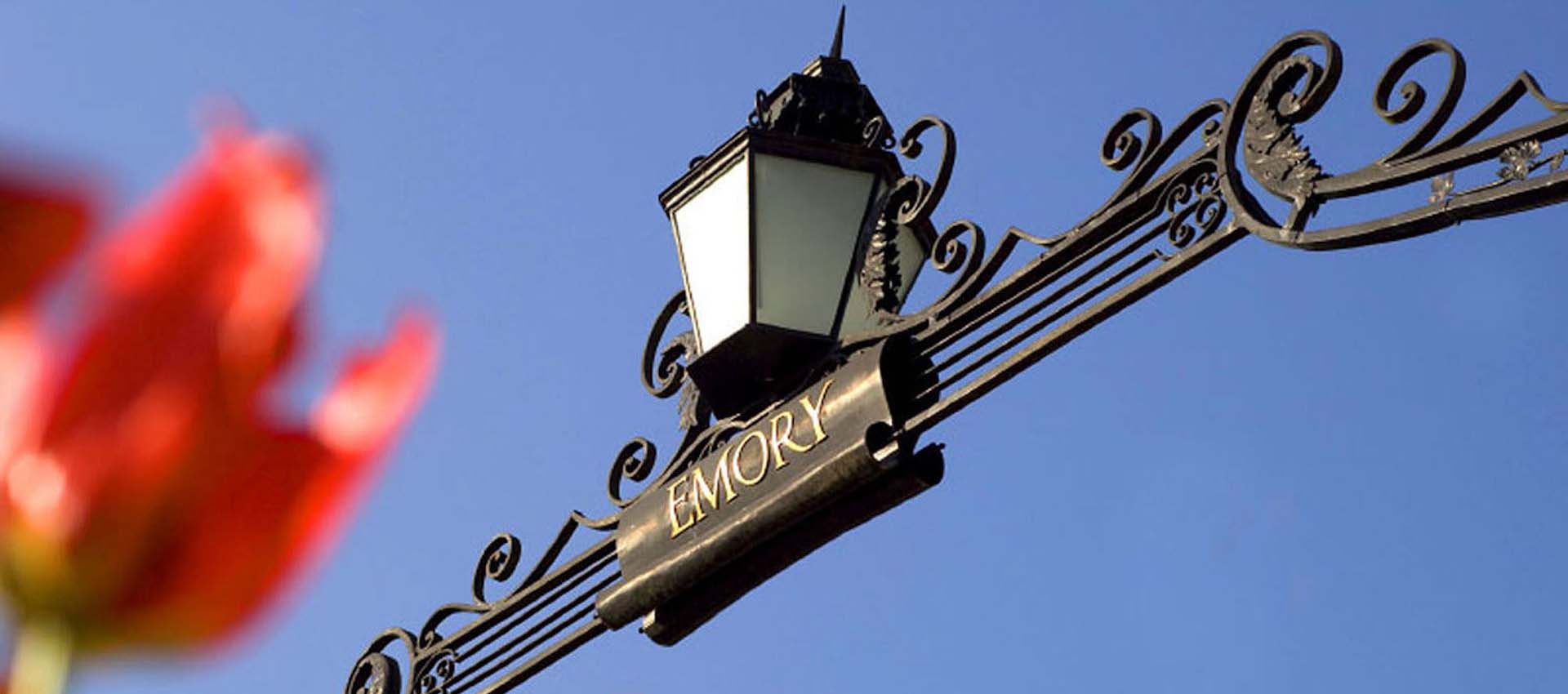 Lantern and Emory logo on Haygood-Hopkins gate with tulips in the foreground